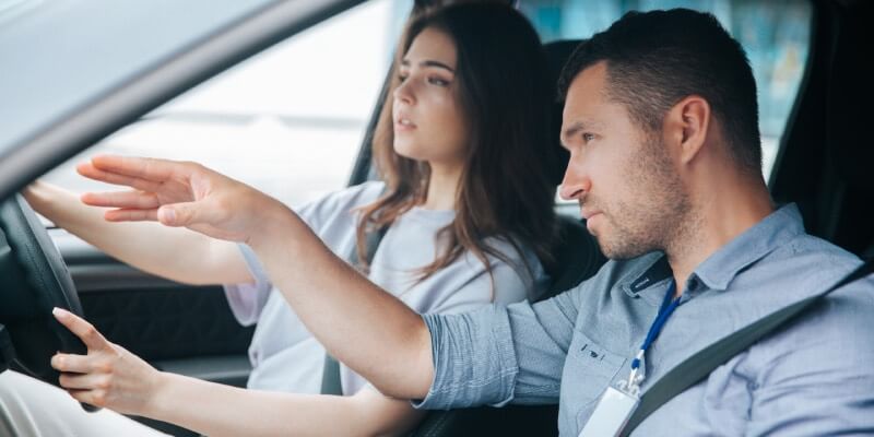 Man and girl in car pointing ahead